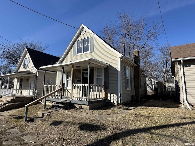 bungalow-style house featuring covered porch and a chimney