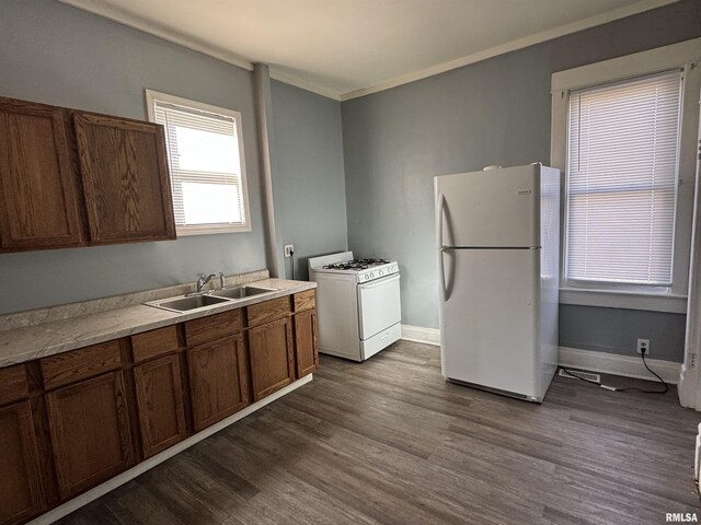 929 W Brons Ave, Peoria, IL 61604 - kitchen featuring ornamental molding, a sink, white appliances, baseboards, and dark wood-style flooring