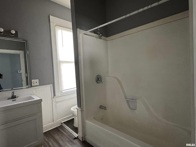 929 W Brons Ave, Peoria, IL 61604 - bathroom with vanity, wood finished floors, wainscoting, bathing tub / shower combination, and toilet