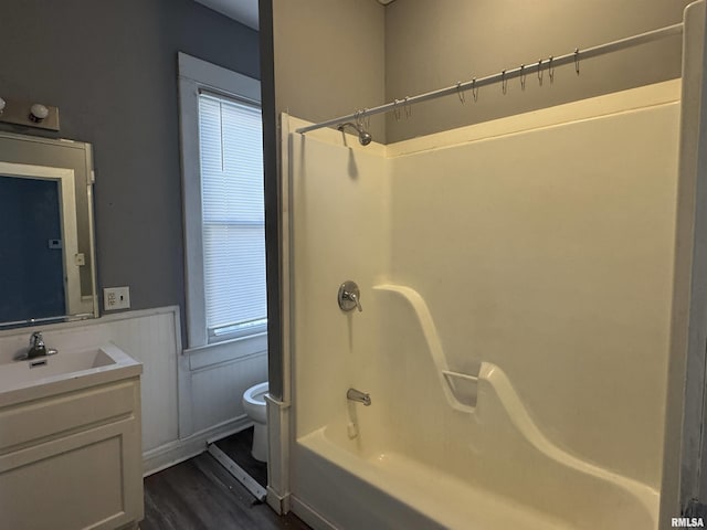 929 W Brons Ave, Peoria, IL 61604 - full bathroom with a wainscoted wall, toilet, wood finished floors, washtub / shower combination, and vanity