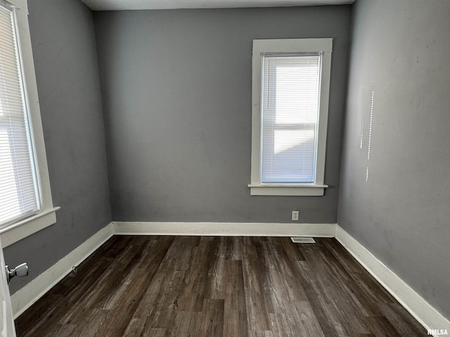 929 W Brons Ave, Peoria, IL 61604 - empty room with visible vents, baseboards, and dark wood-style flooring