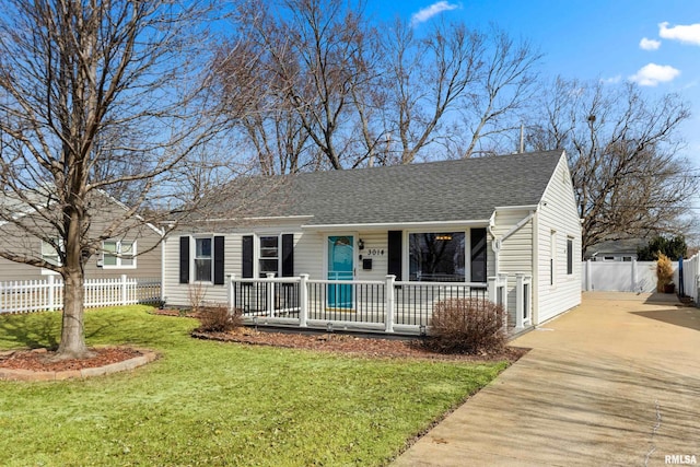 view of front of house featuring a shingled roof, fence, a porch, concrete driveway, and a front yard