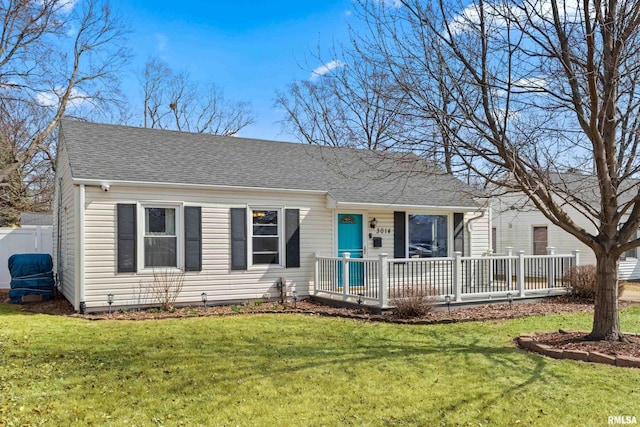 view of front of house featuring a front lawn and roof with shingles