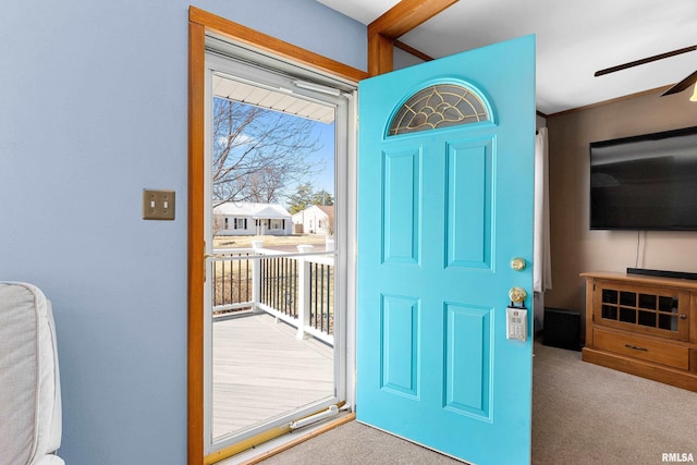 foyer entrance with carpet floors and ceiling fan