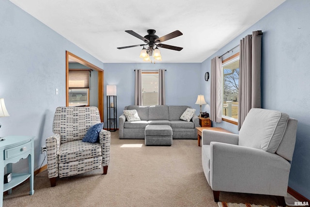 carpeted living room featuring baseboards and ceiling fan