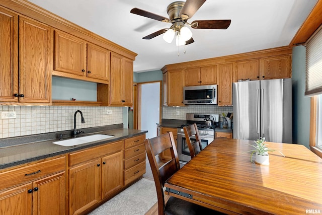 kitchen featuring brown cabinets, a sink, open shelves, appliances with stainless steel finishes, and decorative backsplash