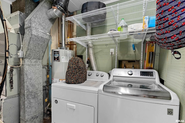 laundry room with laundry area, heating unit, independent washer and dryer, and water heater