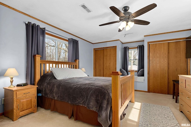 bedroom with light carpet, visible vents, ceiling fan, and ornamental molding