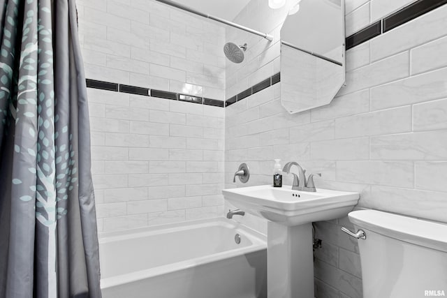 bathroom with shower / bath combo with shower curtain, toilet, and tile walls