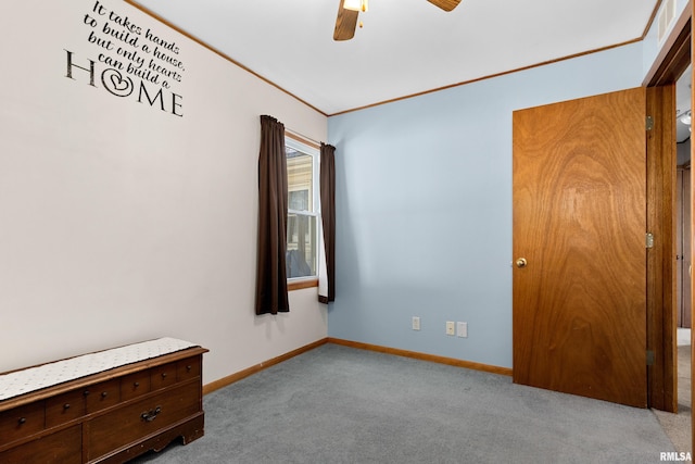 unfurnished bedroom with baseboards, carpet floors, a ceiling fan, and crown molding