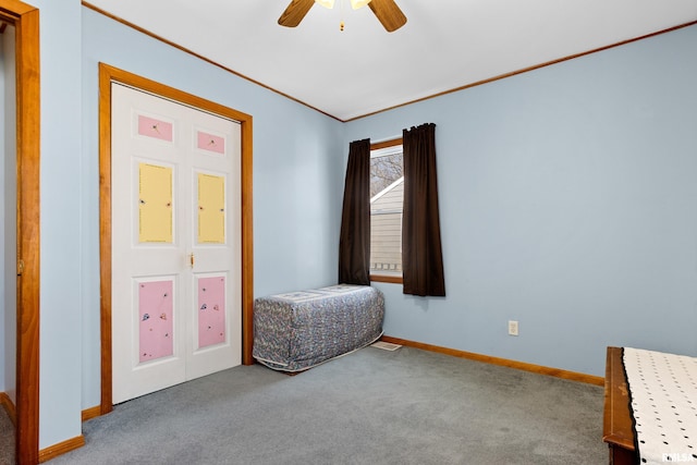 unfurnished bedroom featuring ornamental molding, baseboards, carpet, and a ceiling fan