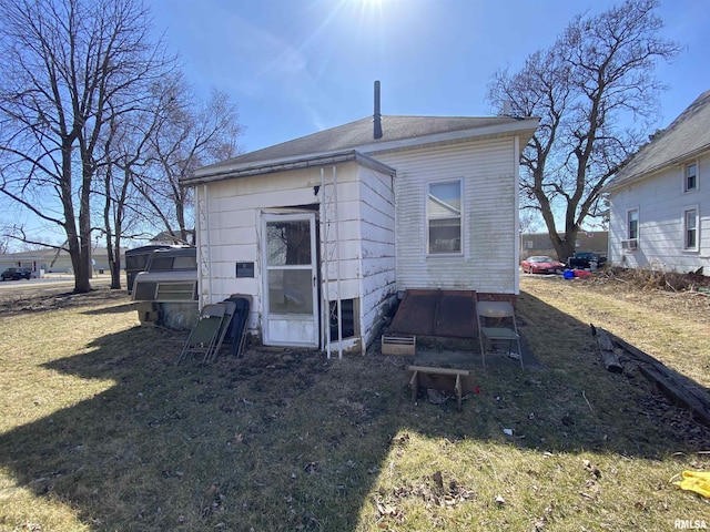 rear view of house featuring a lawn