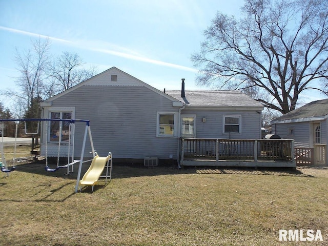 rear view of house featuring a wooden deck, a yard, and a shingled roof