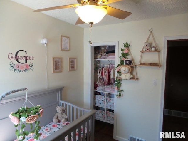 bedroom featuring a closet, visible vents, a textured ceiling, and ceiling fan