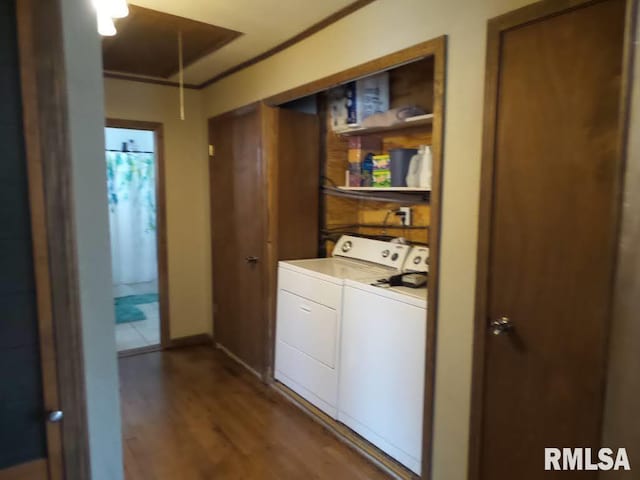 laundry area featuring wood finished floors, washing machine and dryer, baseboards, attic access, and laundry area