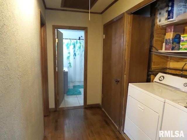 laundry room featuring wood finished floors, washing machine and dryer, crown molding, attic access, and laundry area