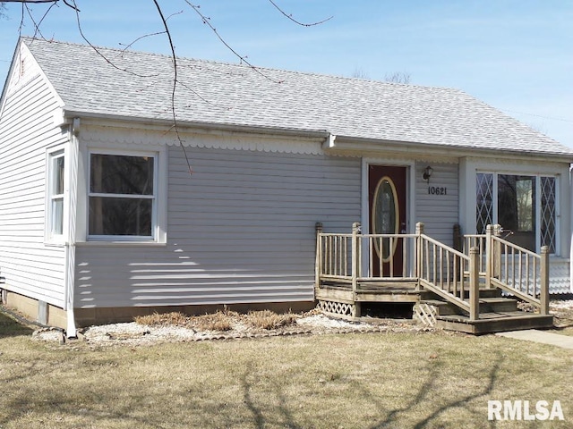 view of front of property featuring a front yard and a shingled roof