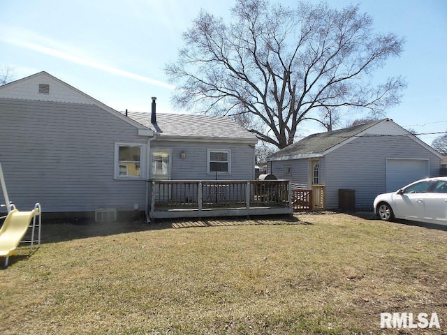 back of house with a lawn, a wooden deck, and a garage