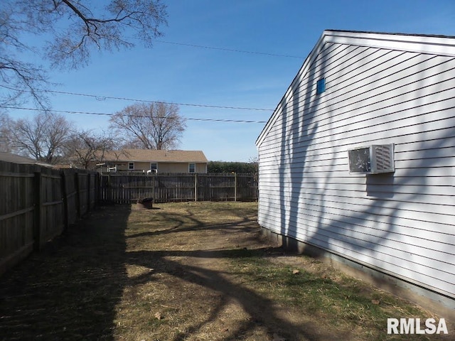 view of yard with a fenced backyard and a wall unit AC