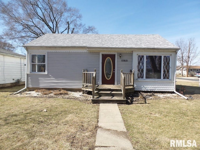 view of front of property featuring roof with shingles and a front yard