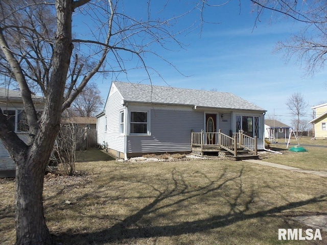 view of front of property featuring roof with shingles and a front yard