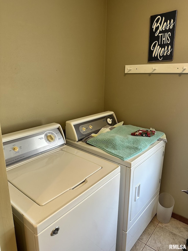 clothes washing area featuring laundry area, light tile patterned floors, separate washer and dryer, and baseboards