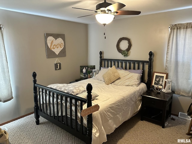 carpeted bedroom featuring baseboards, visible vents, and ceiling fan