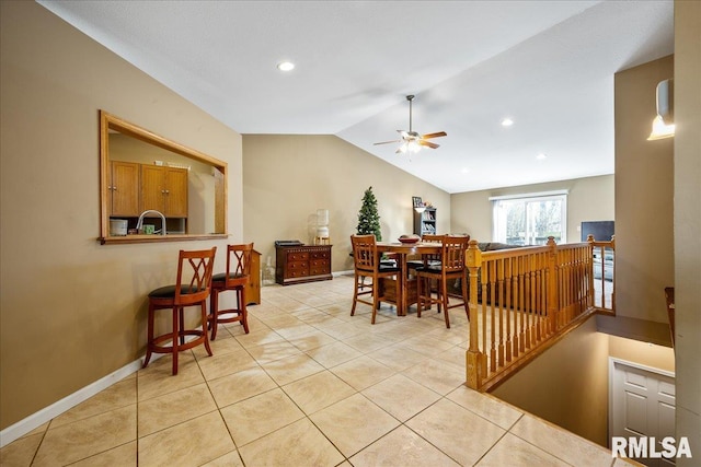 dining space with lofted ceiling, light tile patterned flooring, a ceiling fan, and baseboards