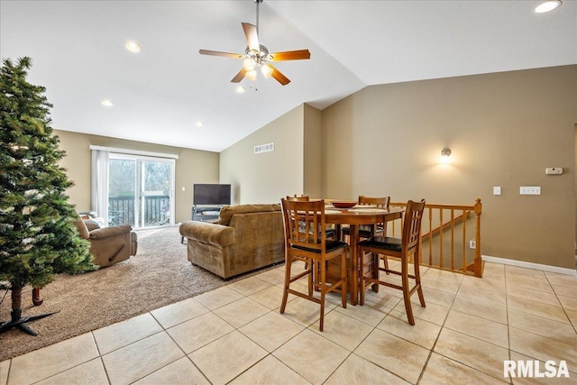 dining area with a ceiling fan, visible vents, light tile patterned flooring, vaulted ceiling, and light colored carpet