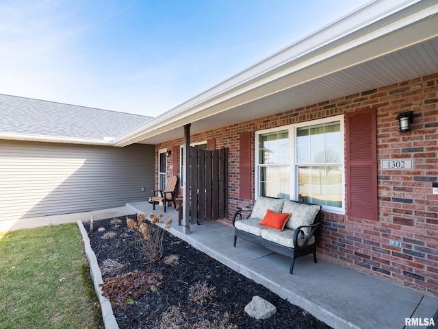 entrance to property with brick siding and a porch