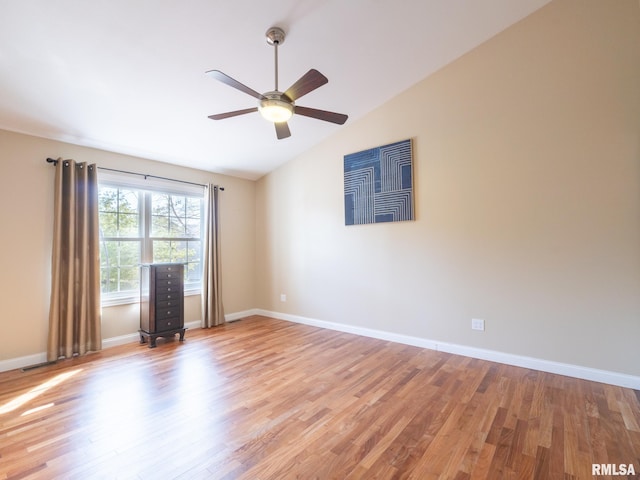 spare room with lofted ceiling, baseboards, light wood-type flooring, and ceiling fan