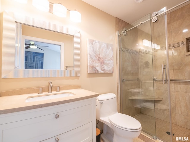 full bathroom with vanity, toilet, ceiling fan, and a shower stall