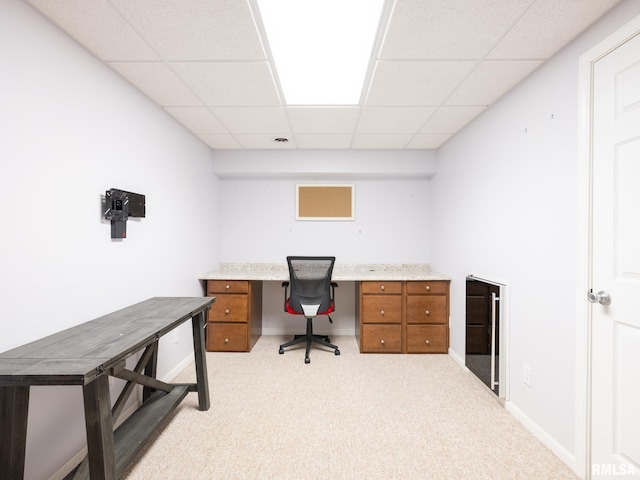 home office with a paneled ceiling, light carpet, baseboards, and beverage cooler