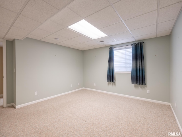 unfurnished room featuring a drop ceiling, baseboards, and carpet floors