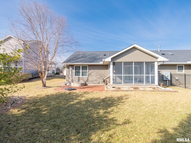 back of property with a yard, fence, and a sunroom