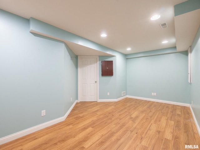 finished below grade area with light wood-type flooring, visible vents, baseboards, and recessed lighting