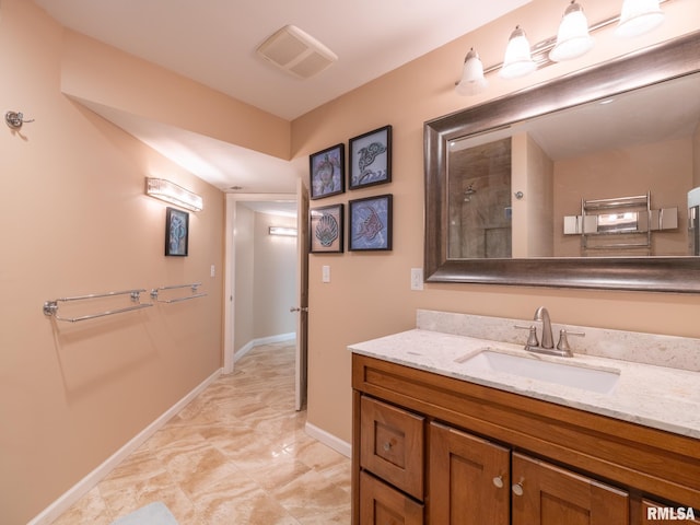 full bath with baseboards, vanity, and a tile shower