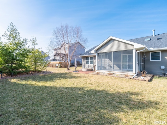 back of house with a lawn, a shingled roof, and a sunroom