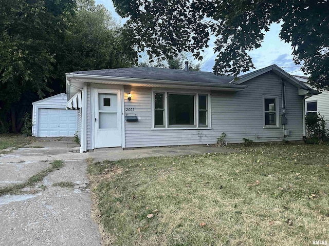 view of front of home with a garage, an outbuilding, and a front lawn