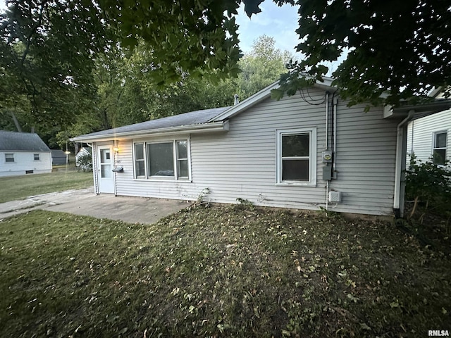 back of property featuring a lawn and a patio area