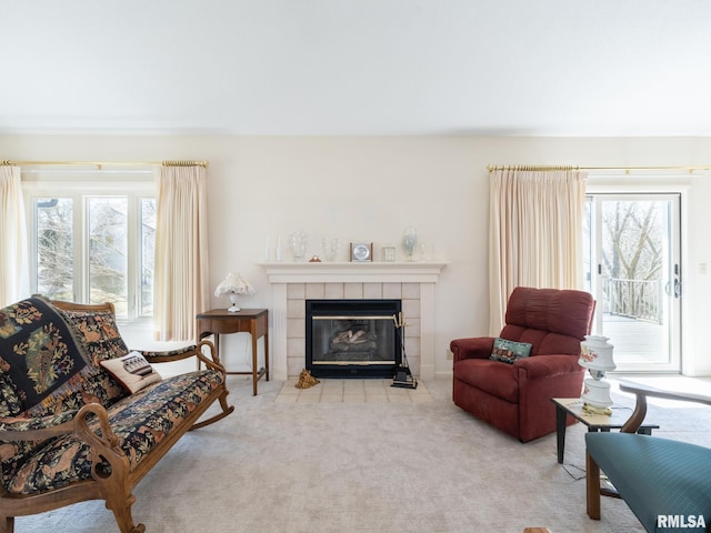 carpeted living room with a tiled fireplace