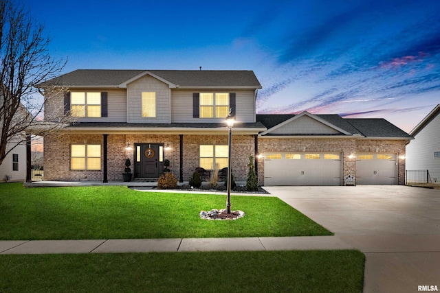 view of front of property featuring a front yard, an attached garage, brick siding, and driveway