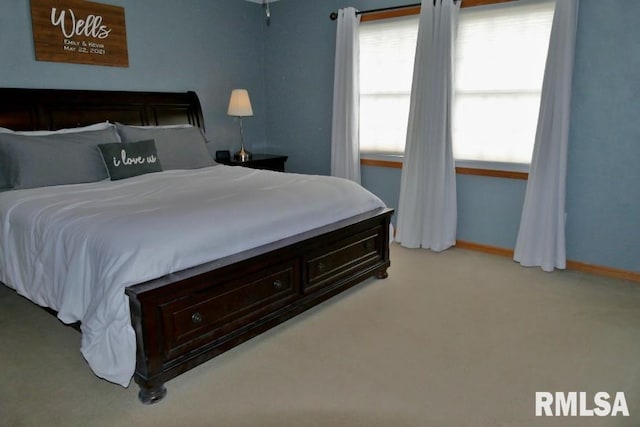 bedroom featuring light colored carpet and baseboards