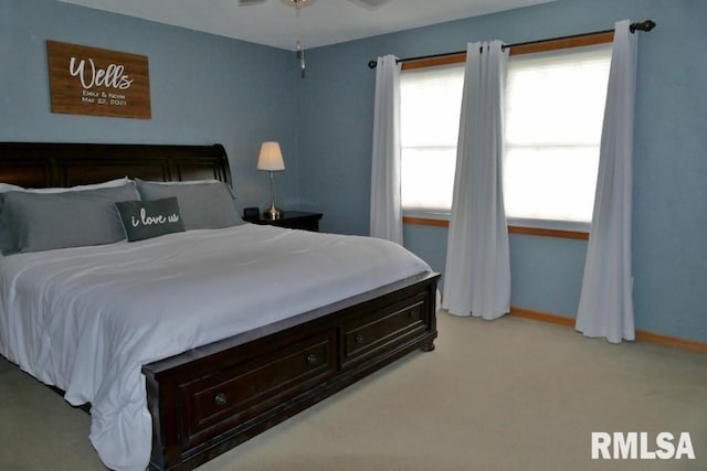 bedroom with light colored carpet and baseboards