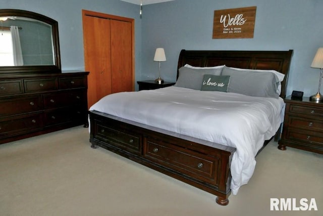 bedroom featuring a closet and light colored carpet