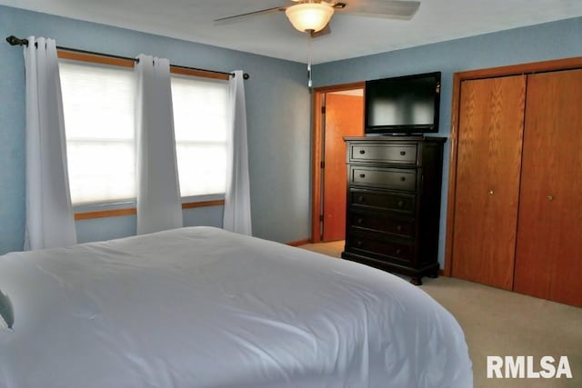 bedroom featuring a closet, light carpet, and ceiling fan