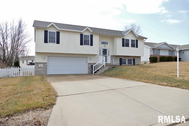 split foyer home featuring brick siding, a front lawn, fence, concrete driveway, and an attached garage