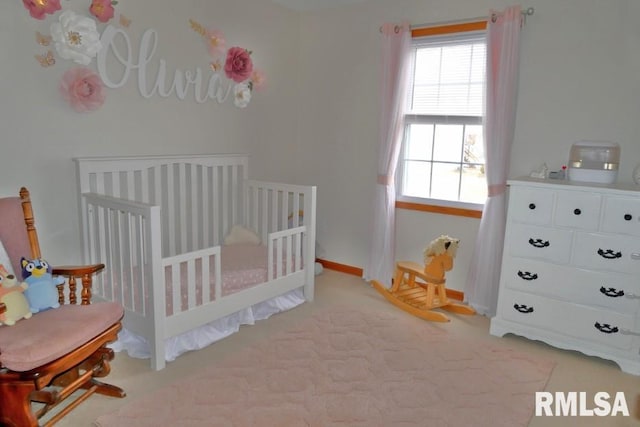 bedroom featuring a nursery area and light colored carpet