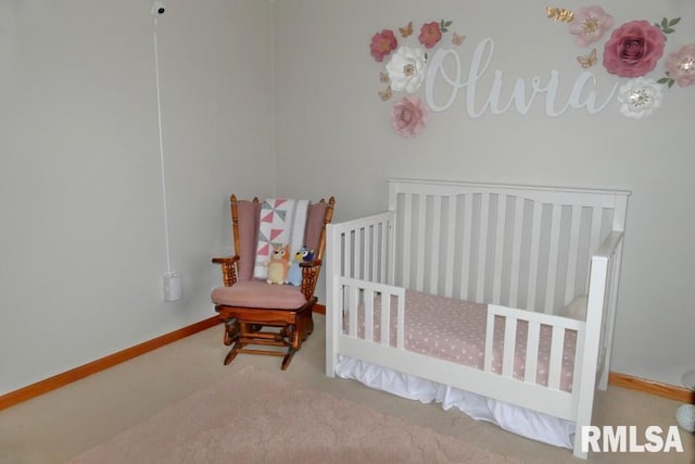 carpeted bedroom featuring a nursery area and baseboards