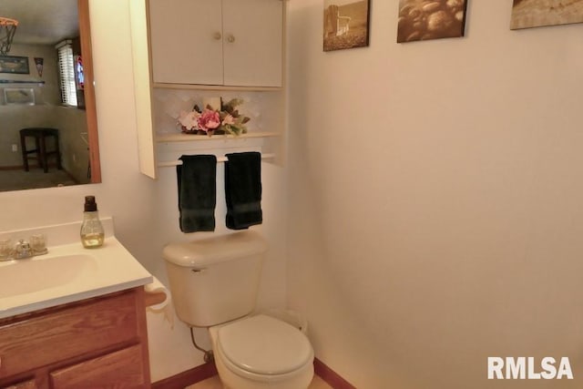 half bathroom featuring vanity, toilet, and backsplash